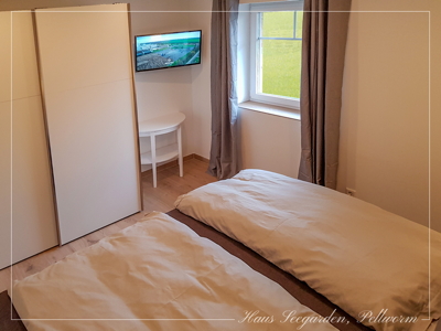 Schlafzimmer mit Boxspringbett und Smart-TV